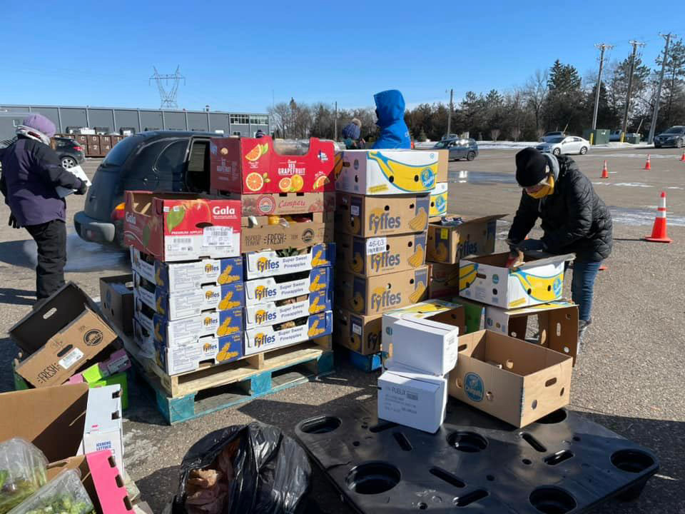 Volunteers move pallets of fresh food intended for hunger relief