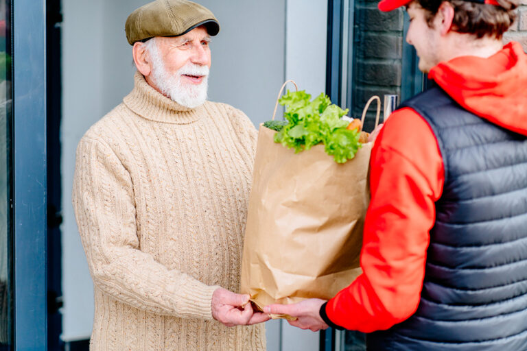 Handing groceries to a man over the age of 65